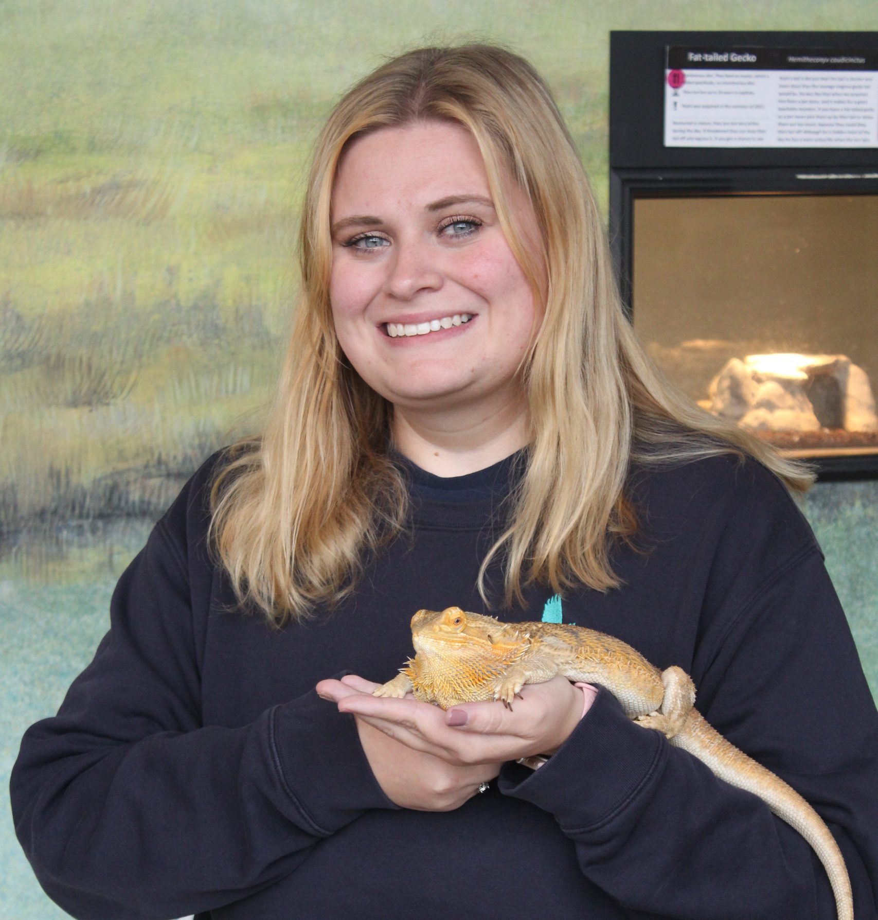 Headshot of Maggie Groce holding a Bearded Dragon.