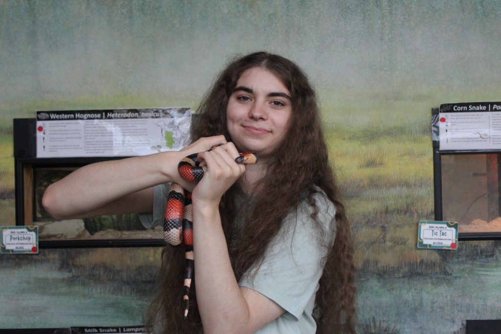 Headshot of Genevieve Egan holding a Milk Snake.